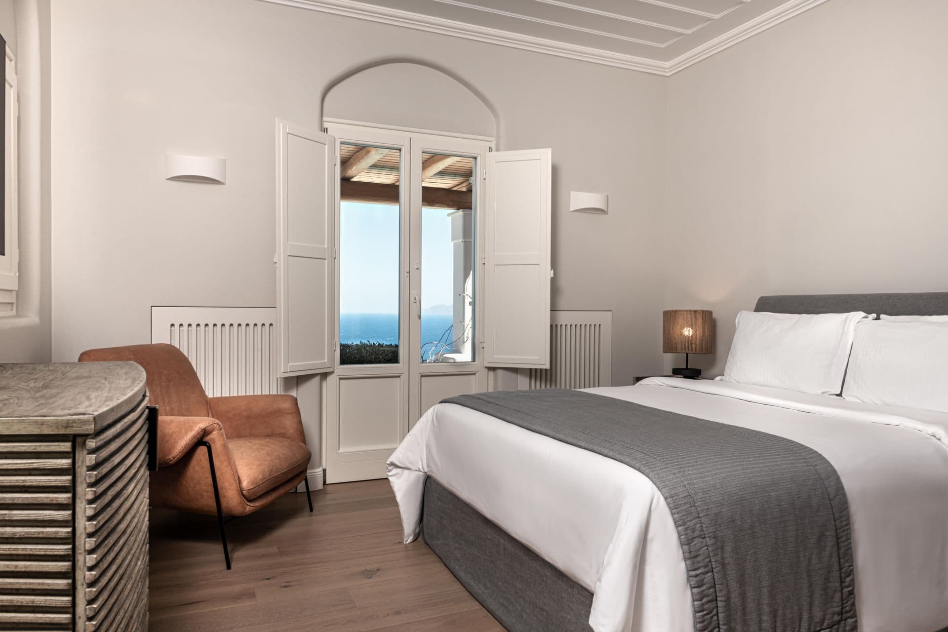 Bedroom with a rust-coloured leather armchair and sea-facing window