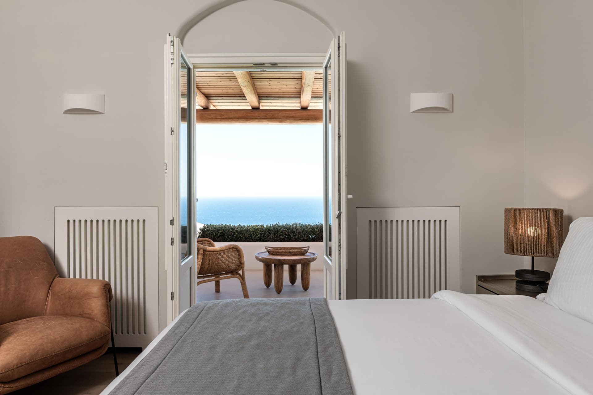Bedroom with French doors opening directly onto a private sea-view terrace