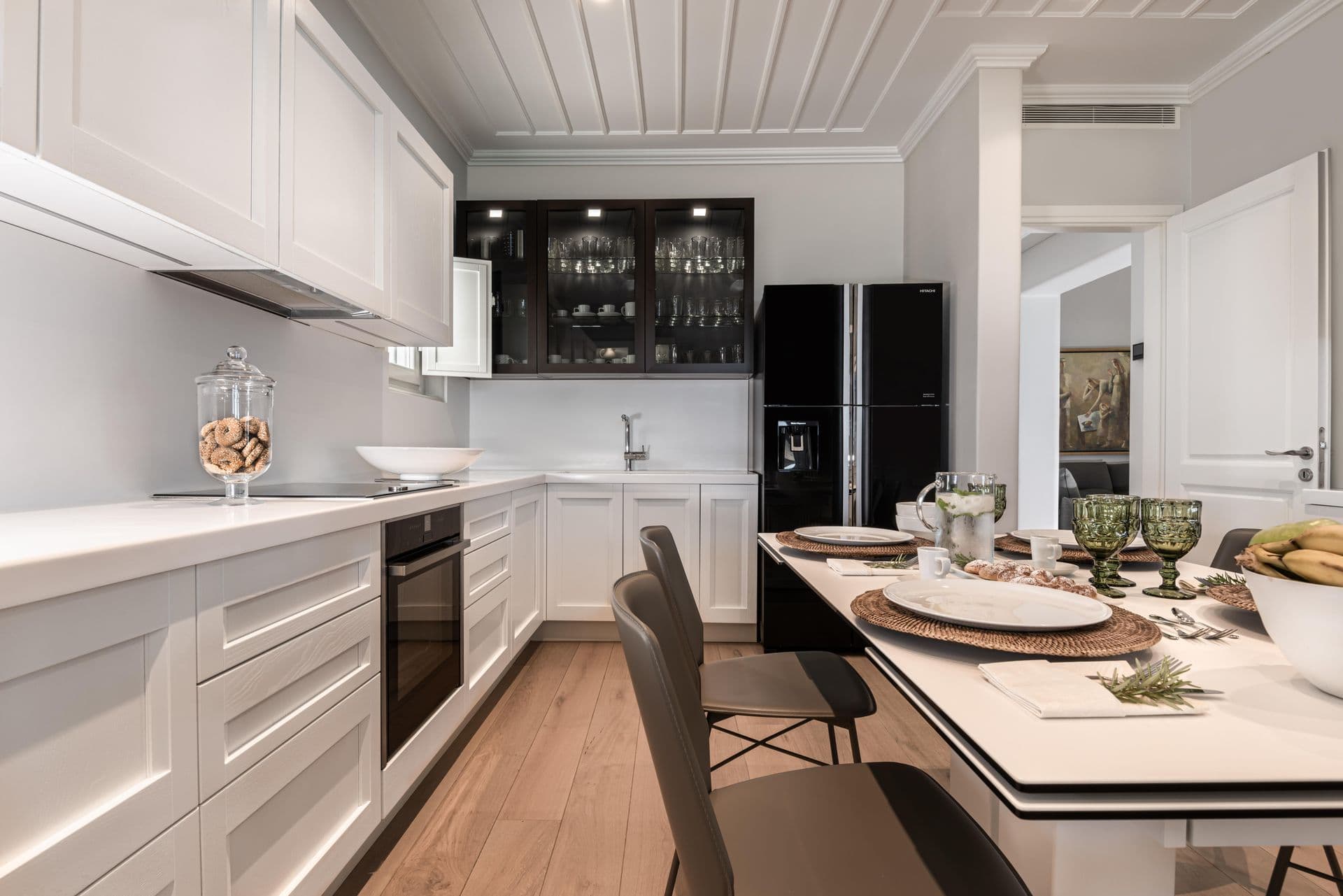 Second kitchen area with dark cabinetry and adjoining breakfast table