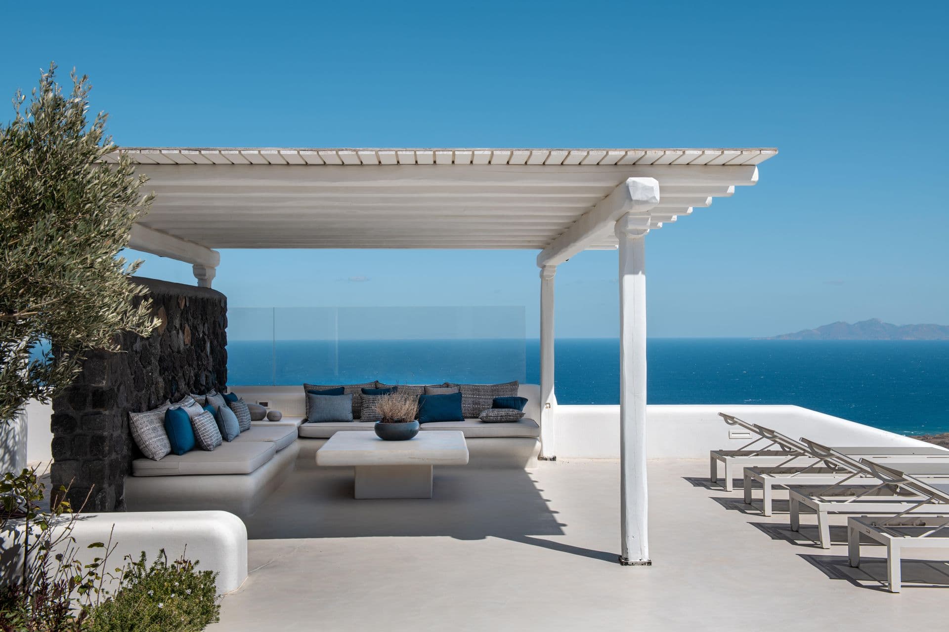 Terrace lounge with built-in stone seating and volcanic rock accent wall