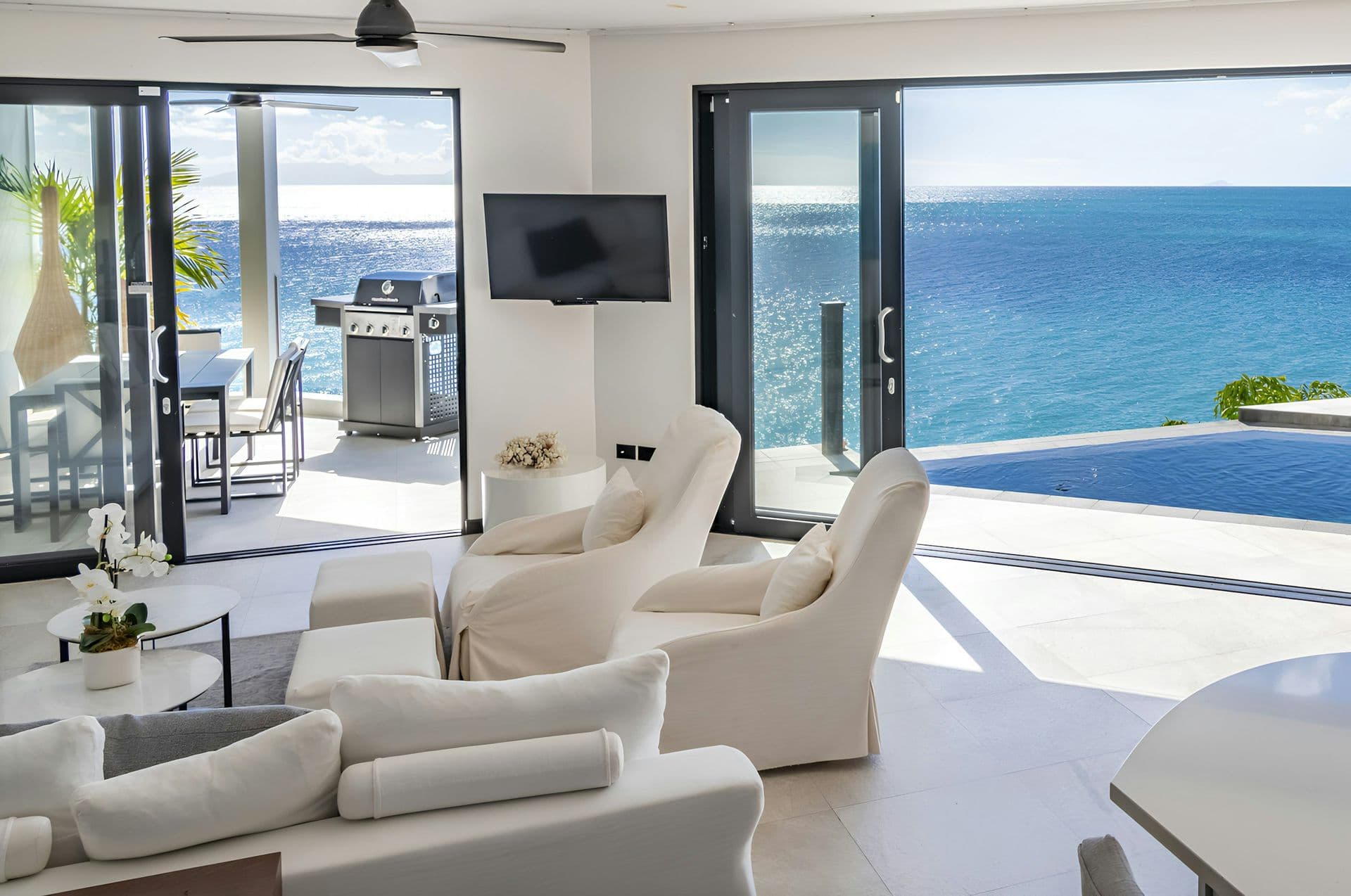 Living room opening to the infinity pool and sea at Life in the Palm, Antigua