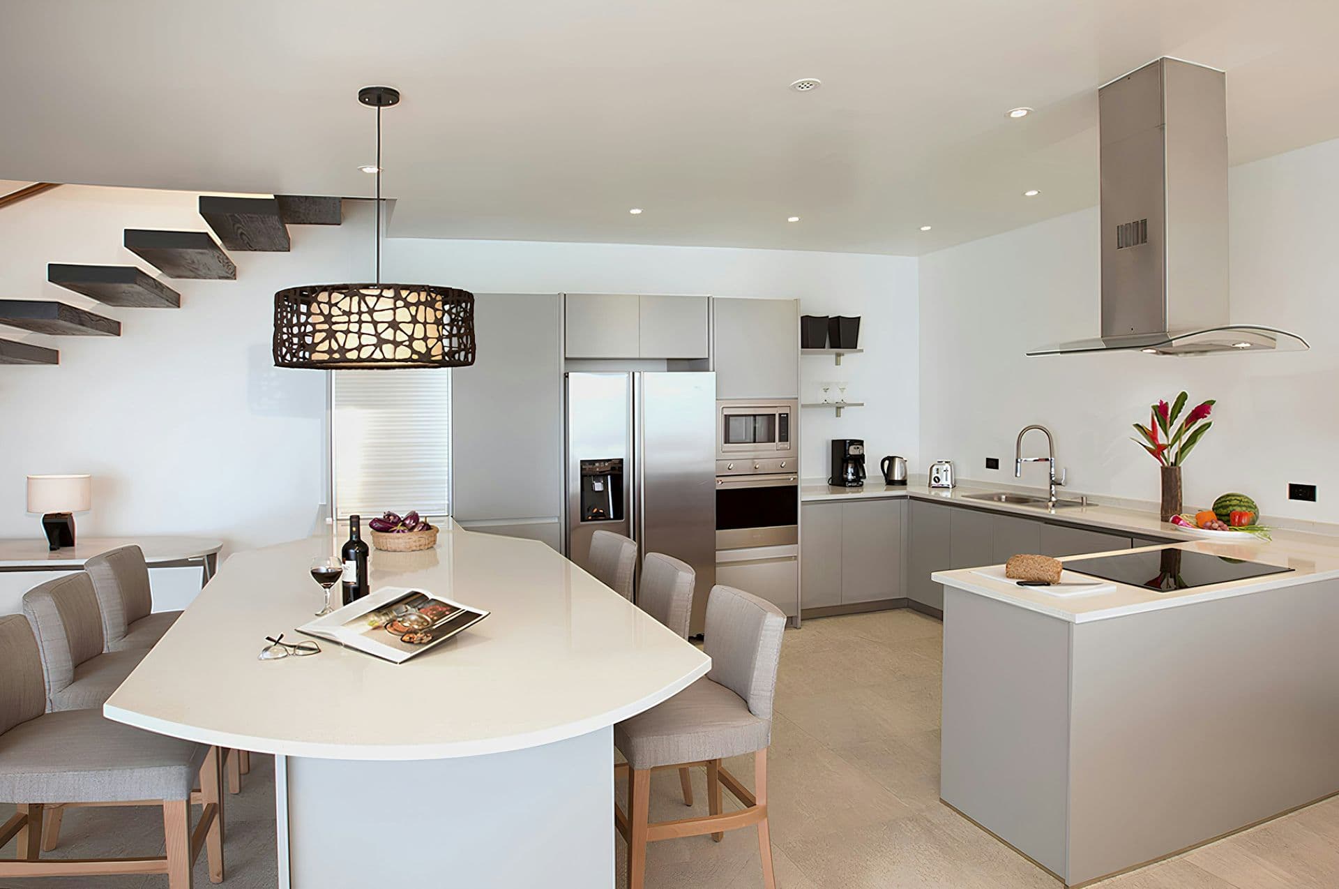 White kitchen with an island and breakfast bar at Life in the Palm, Antigua