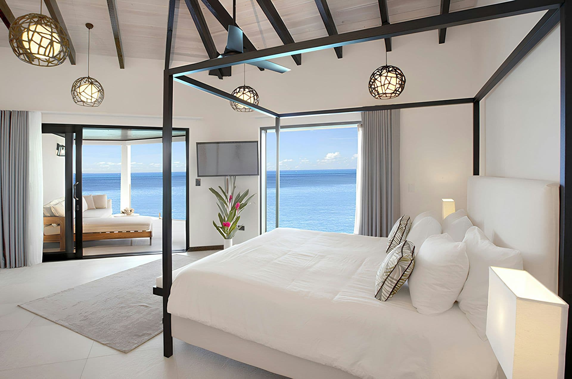 Master bedroom with a four-poster frame and sea view at Life in the Palm, Antigua