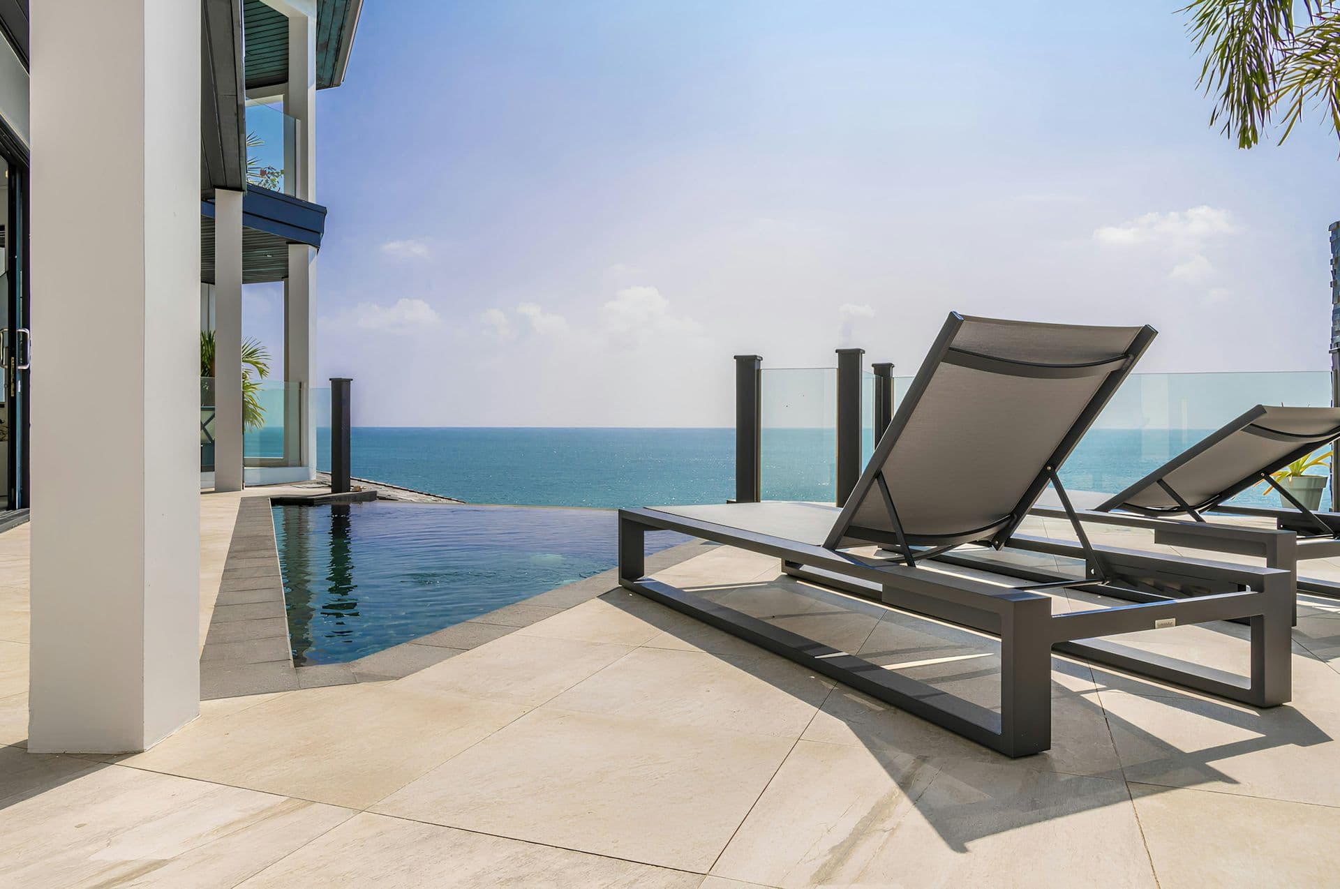 Sun loungers beside the infinity pool with sea views at Life in the Palm, Antigua