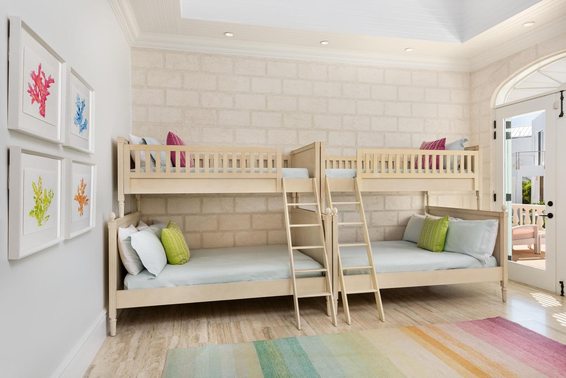Children's bunk room with colourful bedding and beach-themed art