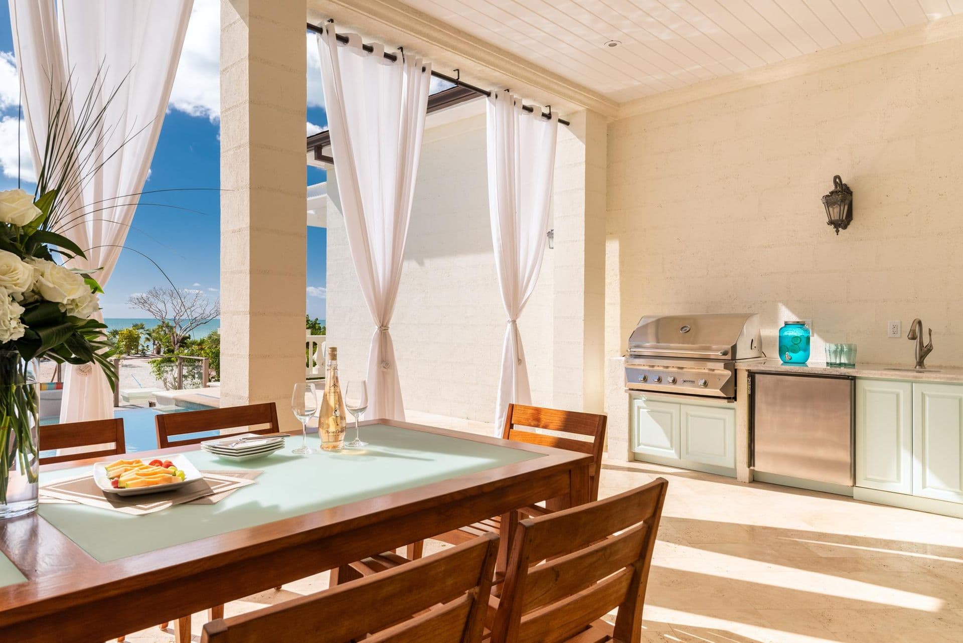 Outdoor dining table set beside the summer kitchen and grill