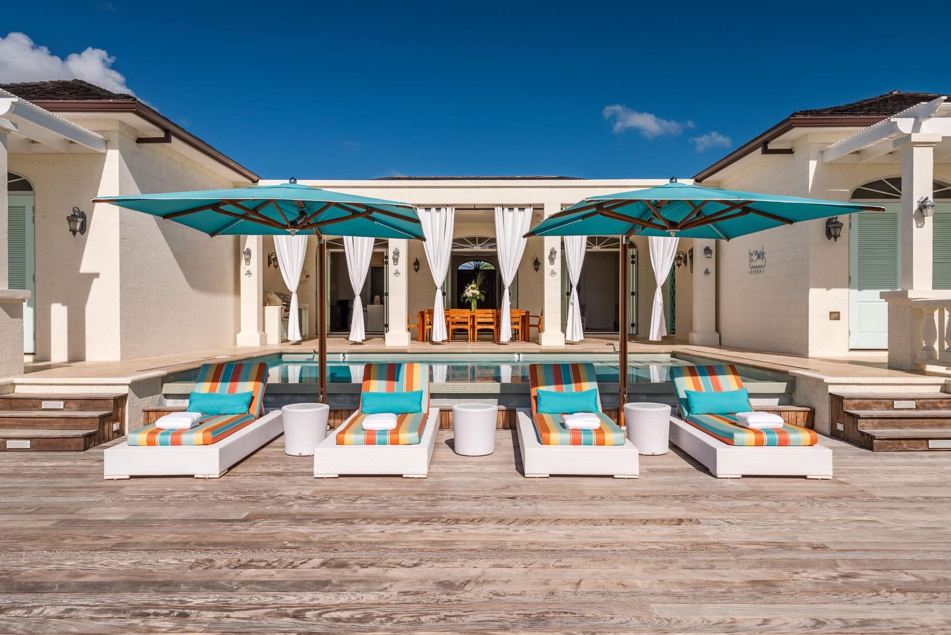 Pool terrace with turquoise loungers and umbrellas