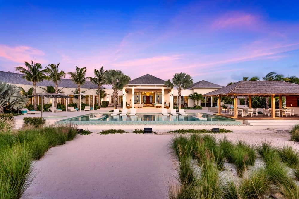 Sentosa villa exterior with open-air pavilion and pool at dusk, Grace Bay, Turks and Caicos