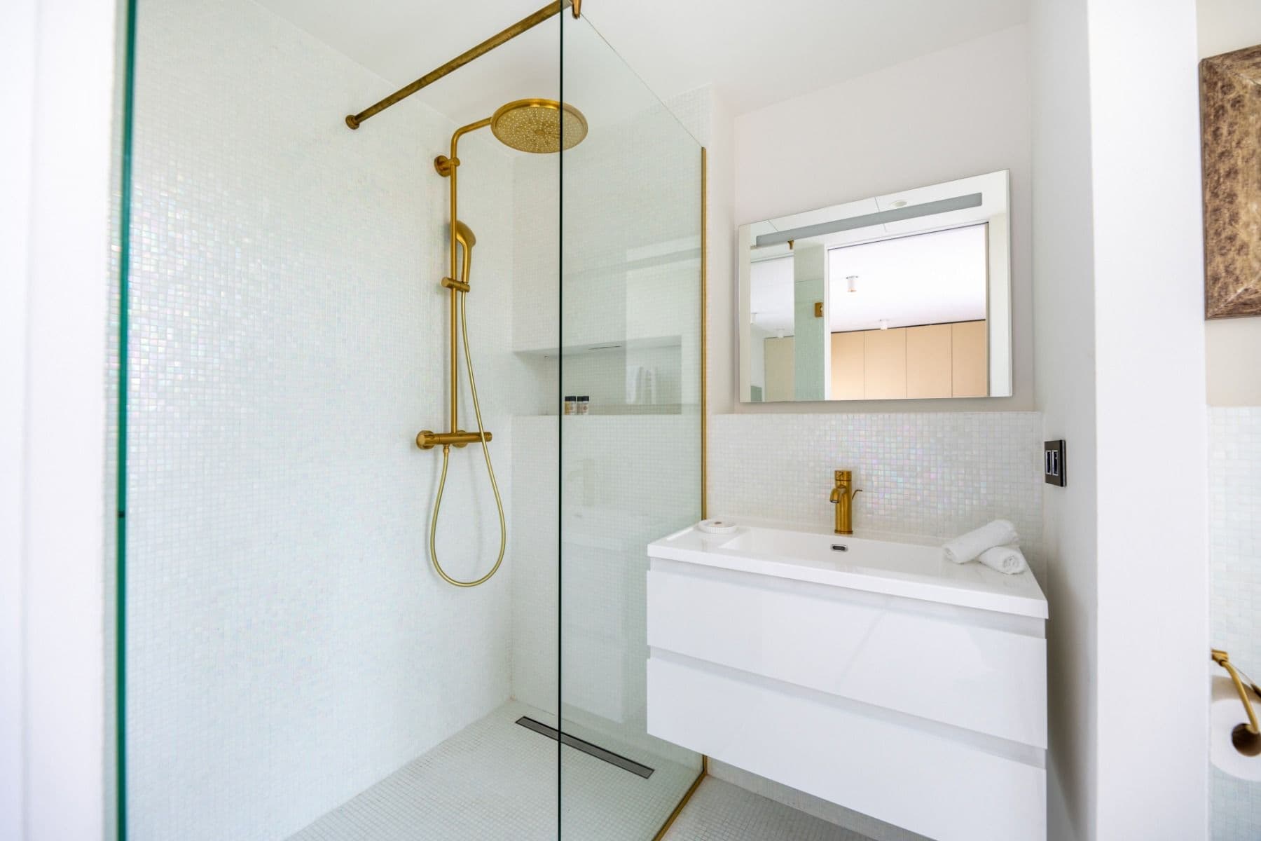 Bathroom with brass rainfall shower fittings and floating vanity