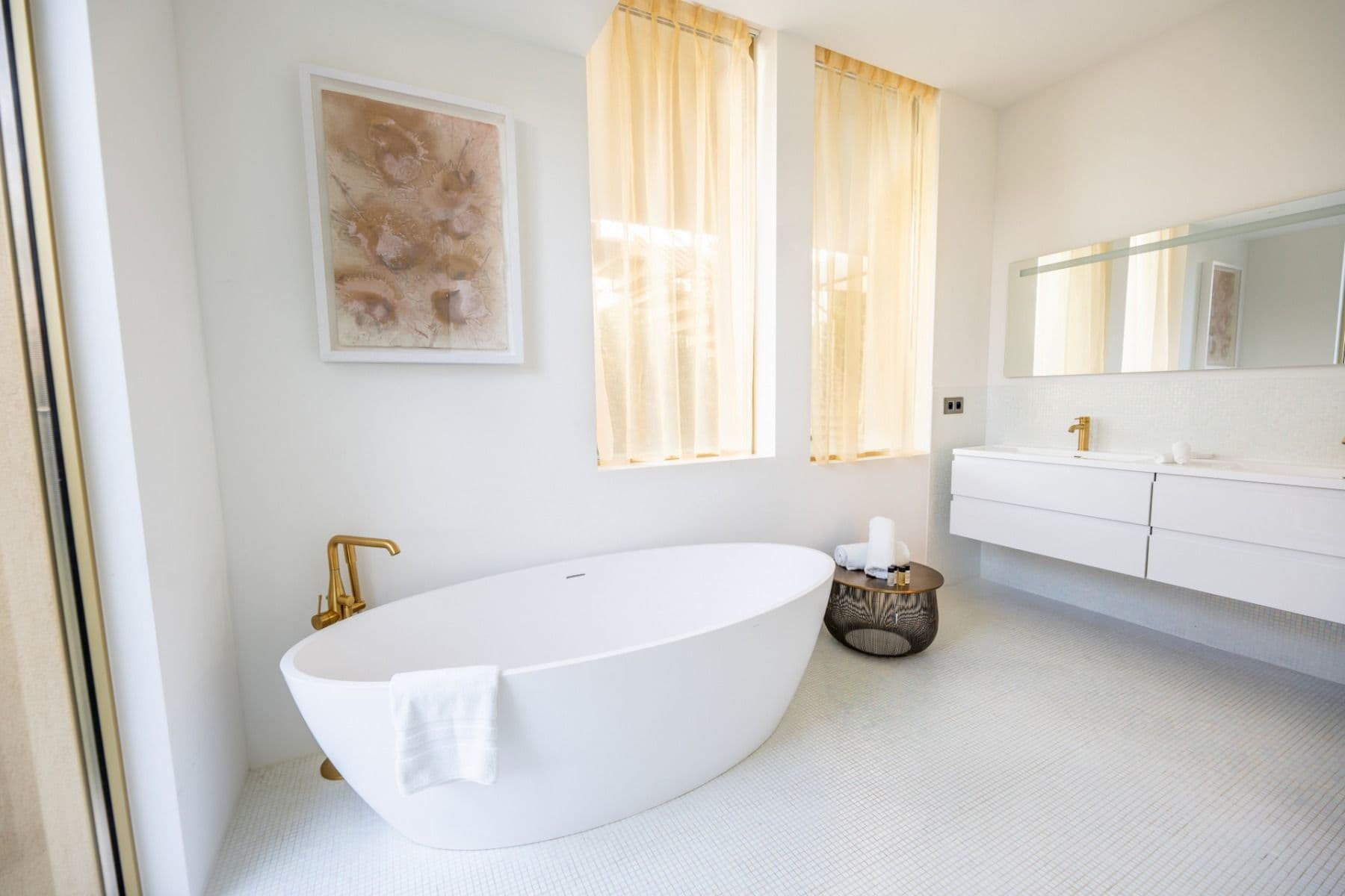 Bathroom with freestanding tub, brass fittings and dual vanity