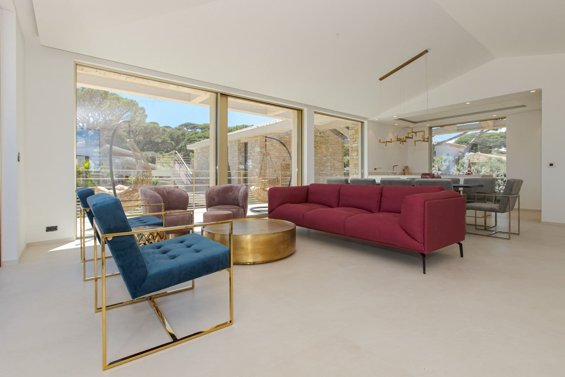 Bright living room with jewel-toned blue and red seating around a brass coffee table