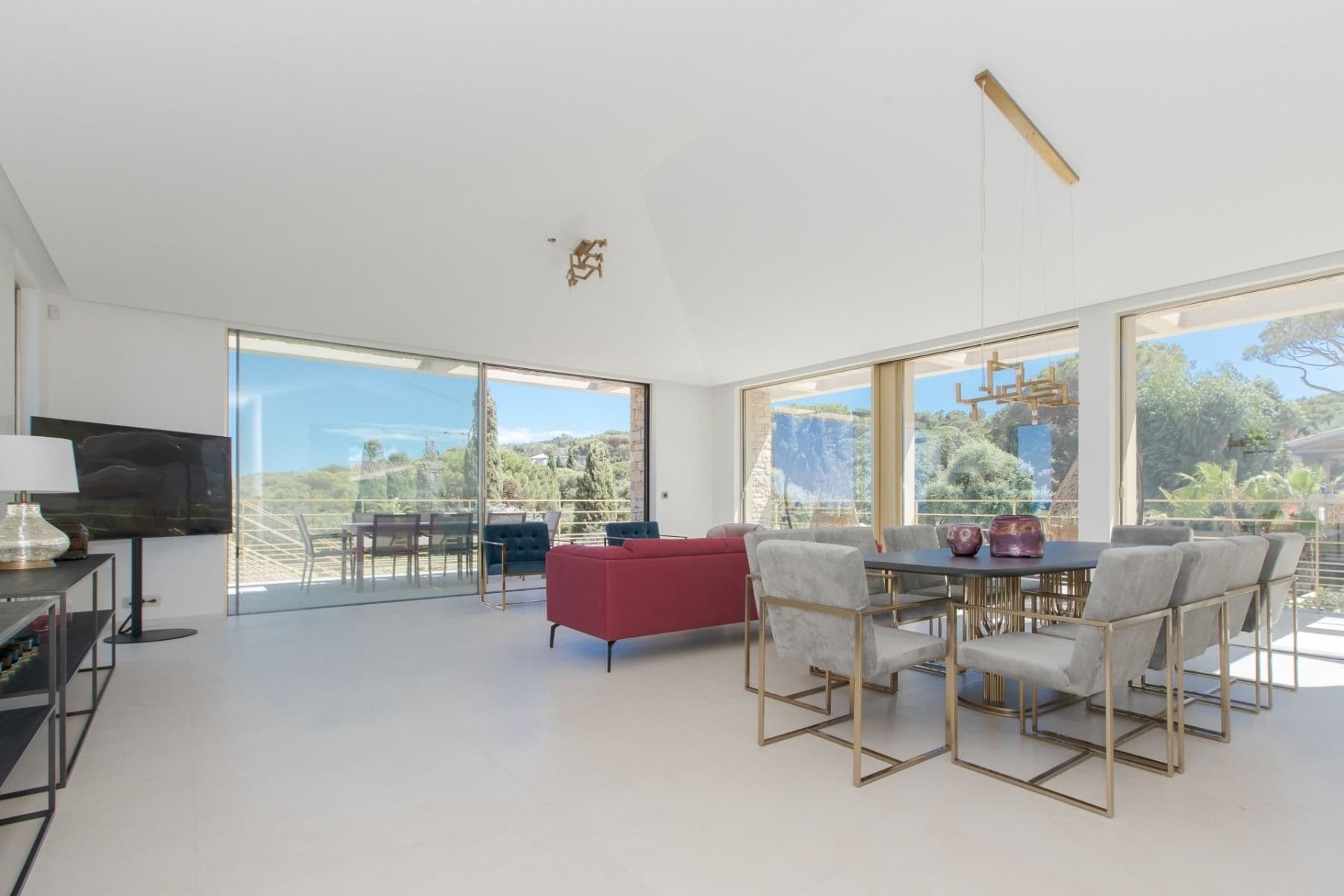 Open-plan living and dining space with a distant sea view through the far window
