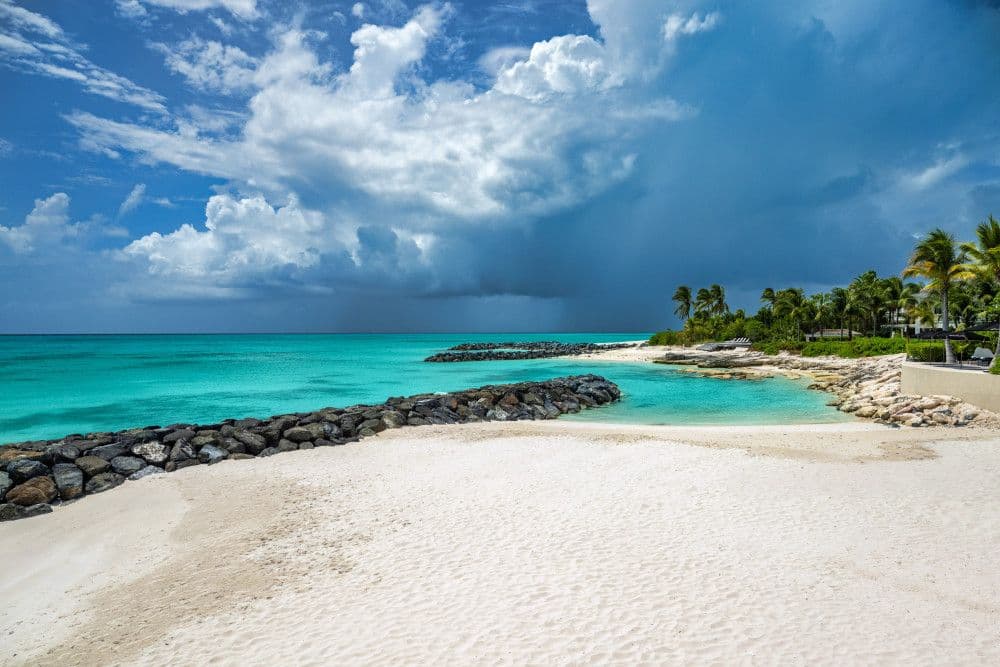 White-sand beach and turquoise cove in front of Villa Awa