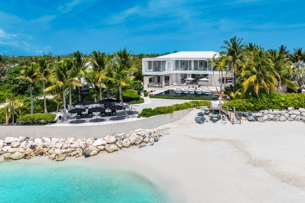Villa Awa seen from the beach with its pool terrace and palms