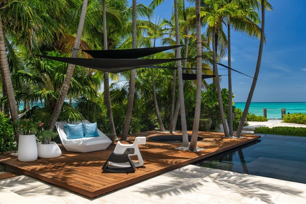 Shaded garden lounge deck among palms at Villa Awa