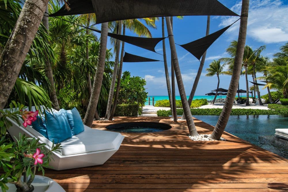 Shaded timber deck with a sunken hot tub and daybed by the pool at Villa Awa