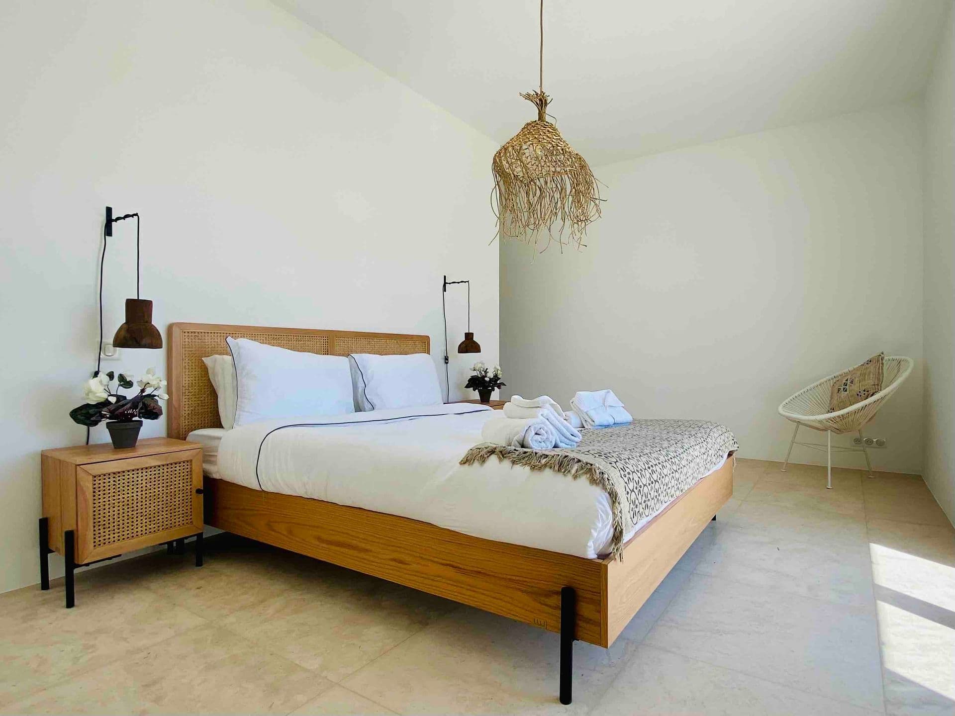 Bedroom with wooden bed frame and a macrame pendant light