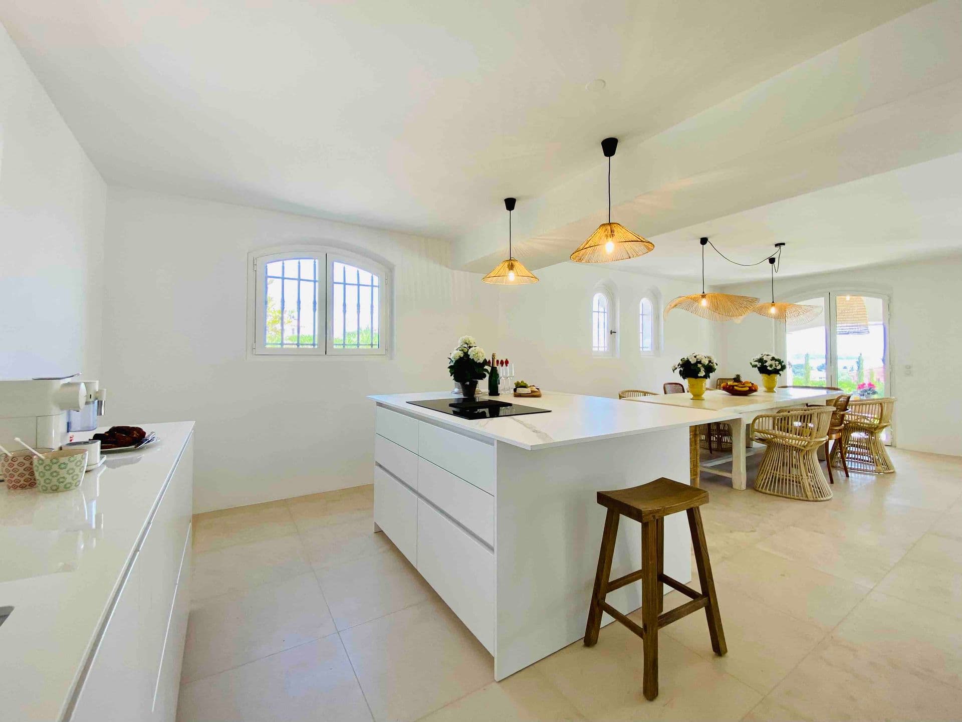 White kitchen island lit by warm pendant lights