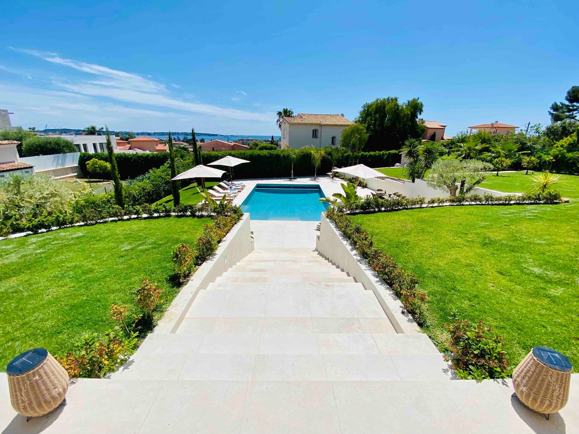 Stone pathway across manicured lawns leading to the pool