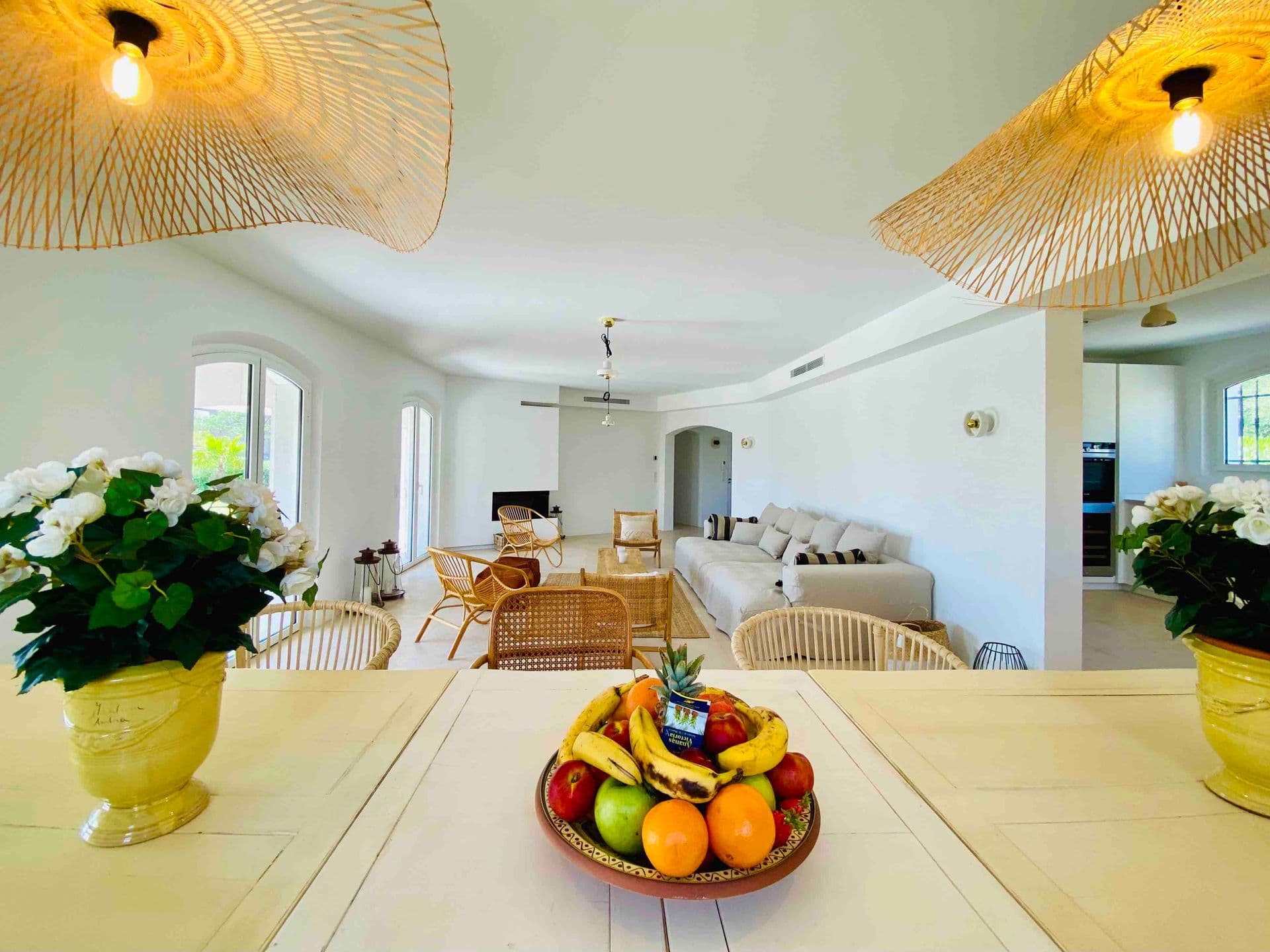 Open-plan kitchen and living space with a fresh fruit bowl on the table
