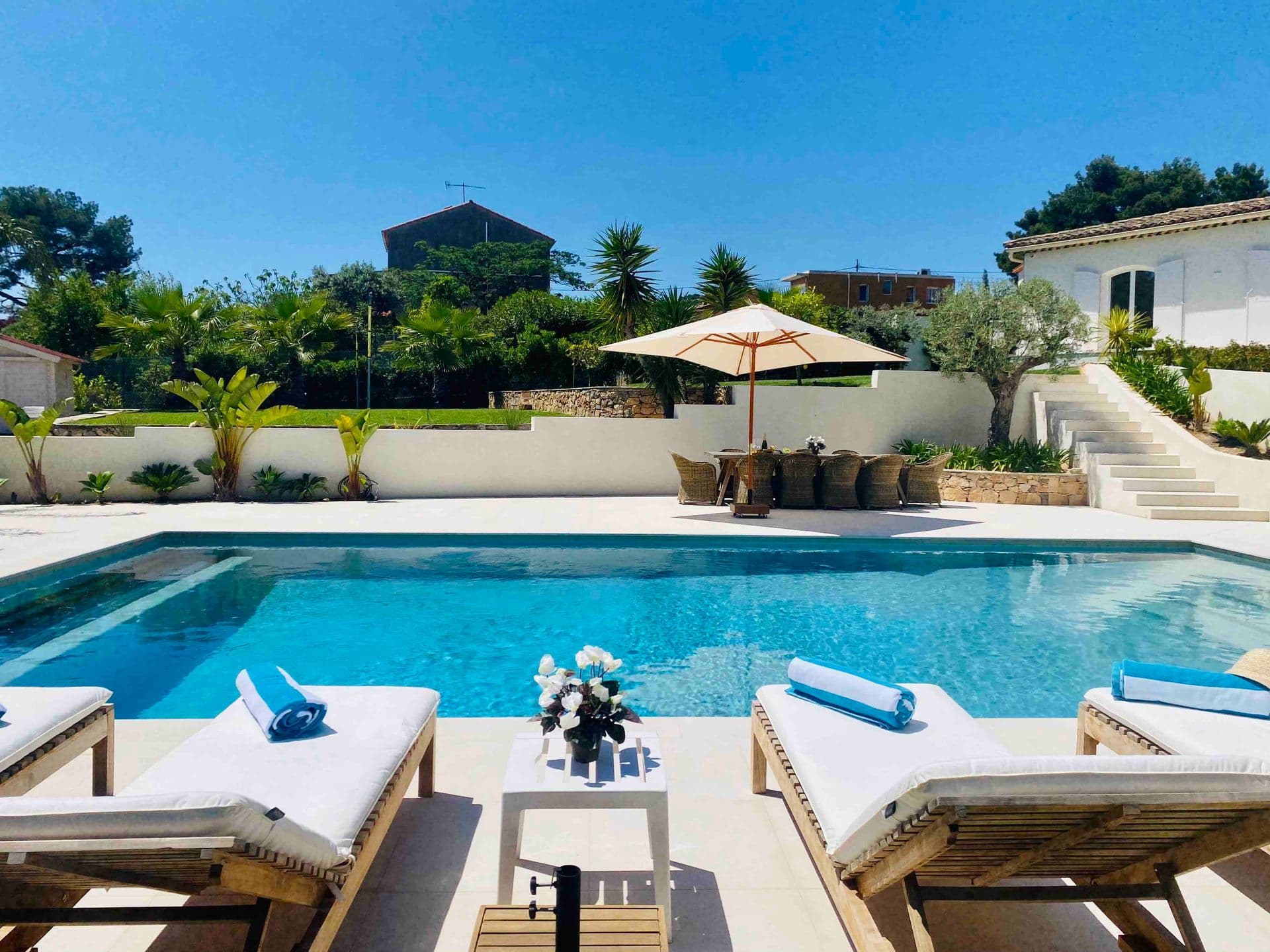 Poolside sun loungers with fresh flowers on a side table