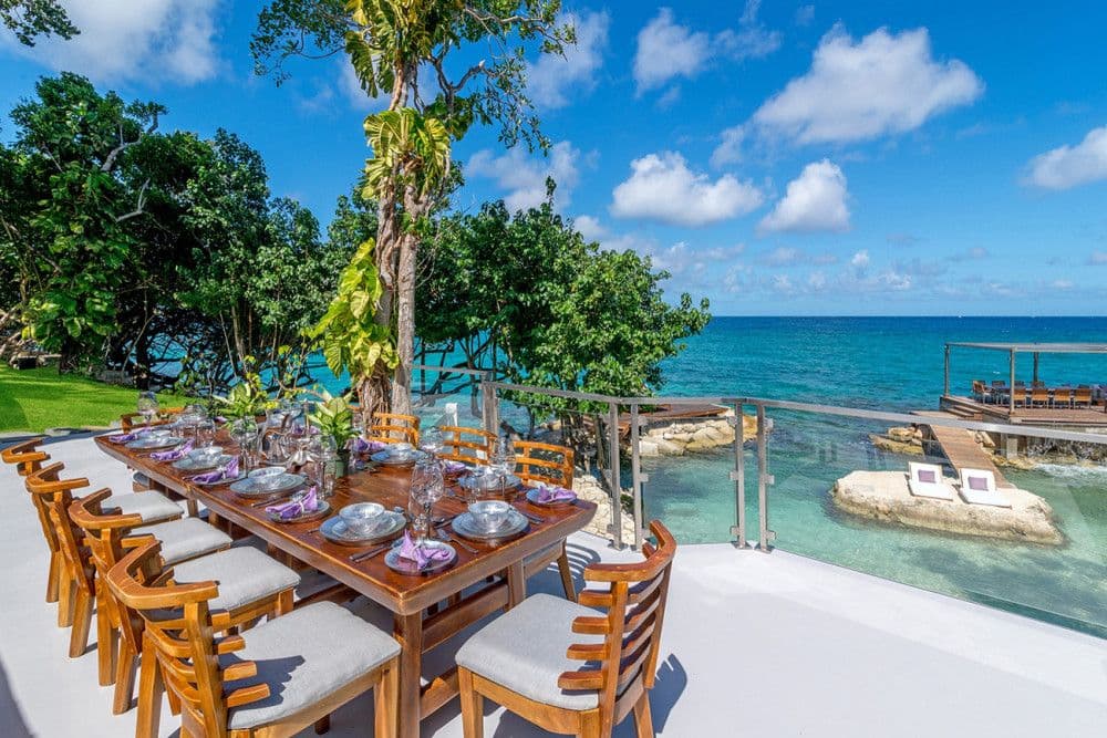 Outdoor dining table for twelve on a terrace above the cove at Promiseas
