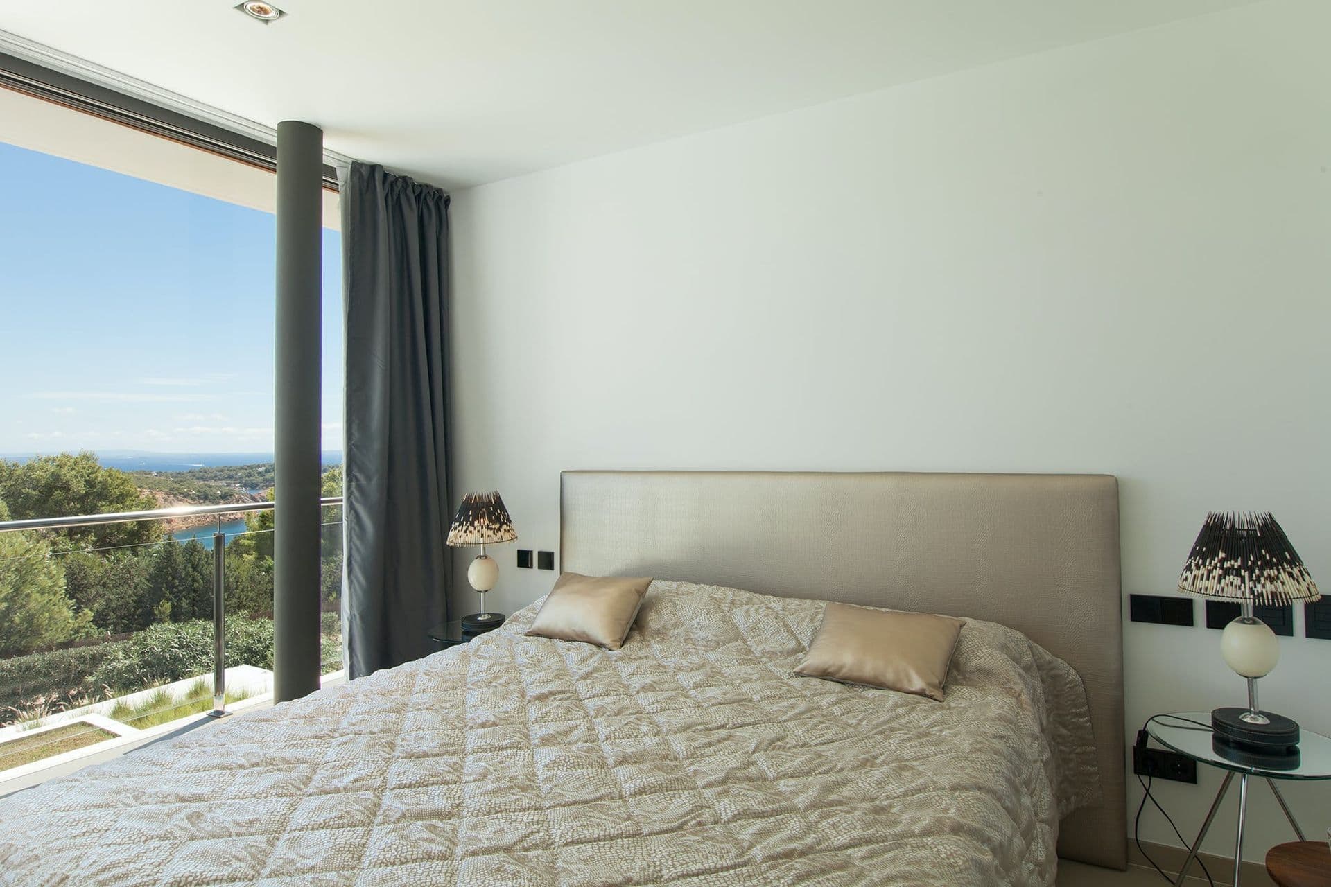 Bedroom decorated in neutral tones with a sea-facing window