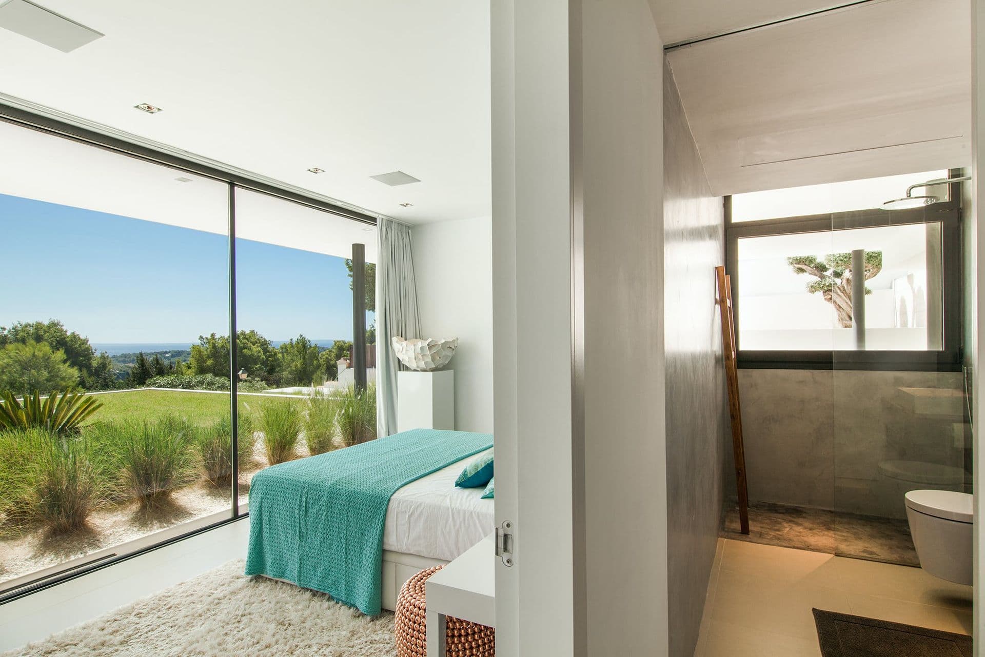 Bedroom with an arc floor lamp and glass doors overlooking the pool