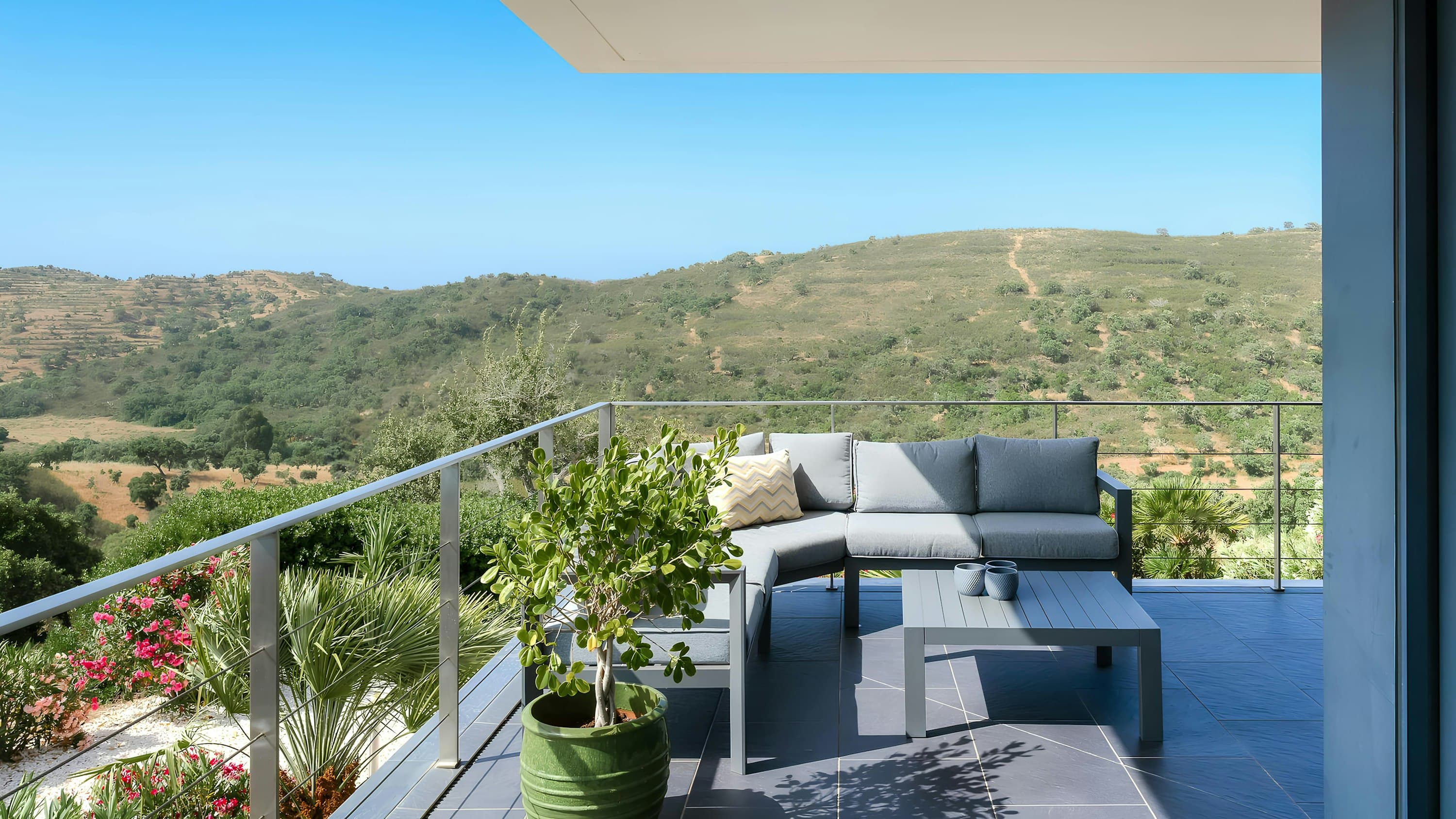 Architectural Lagos terrace with grey sofa and countryside views, Lagos, Algarve, Portugal