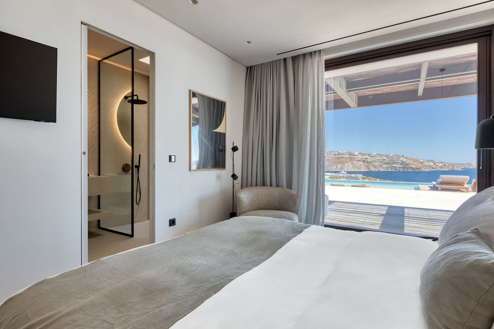 Bedroom with large sea-facing window at Ocean Breeze & Sea Views, Mykonos