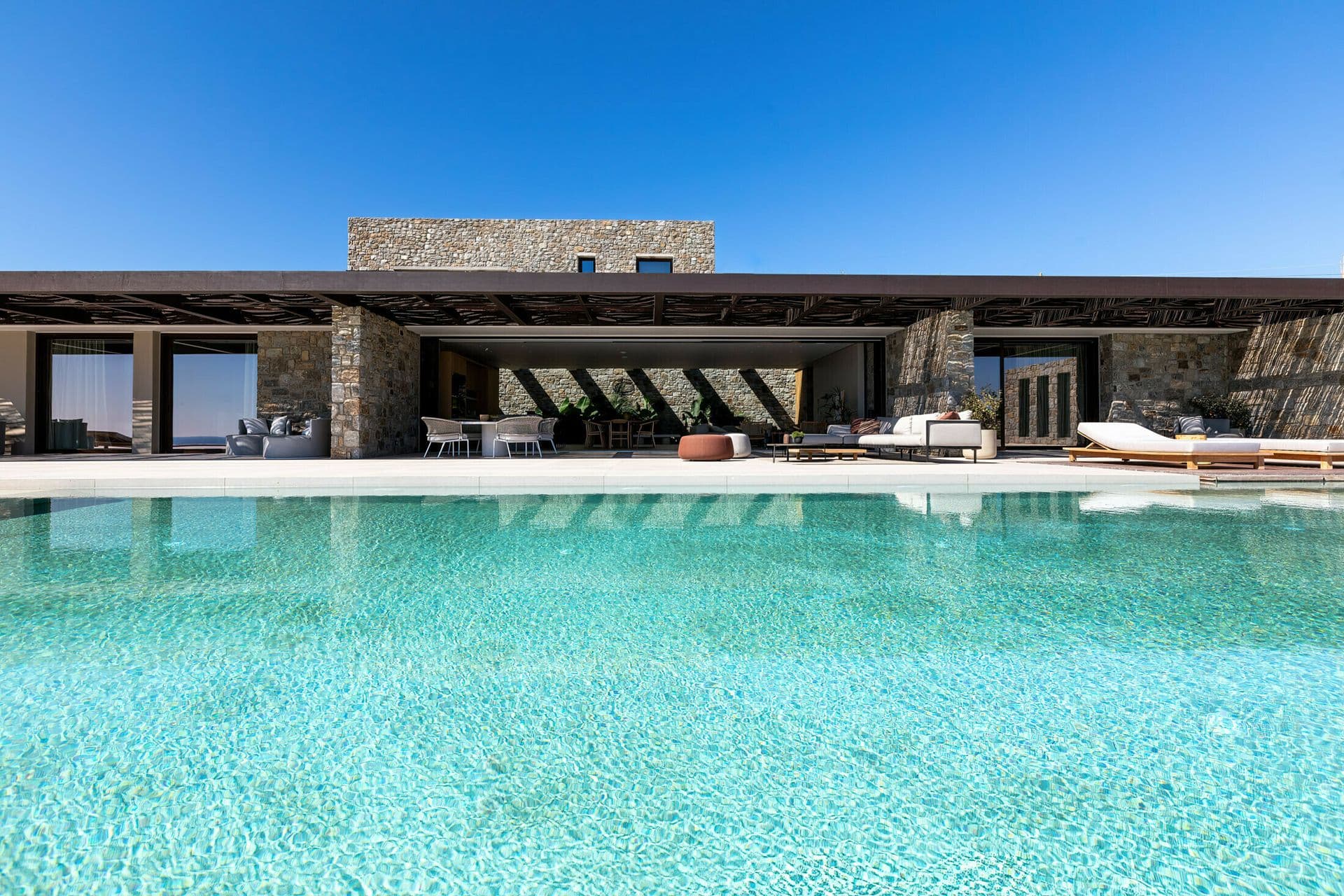 Stone-built villa exterior and pool terrace at Ocean Breeze & Sea Views