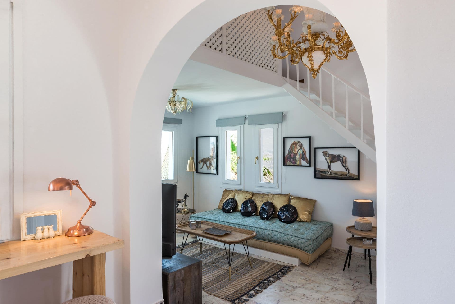 Sitting area beneath a whitewashed archway with framed artwork at Hand of Hygieia