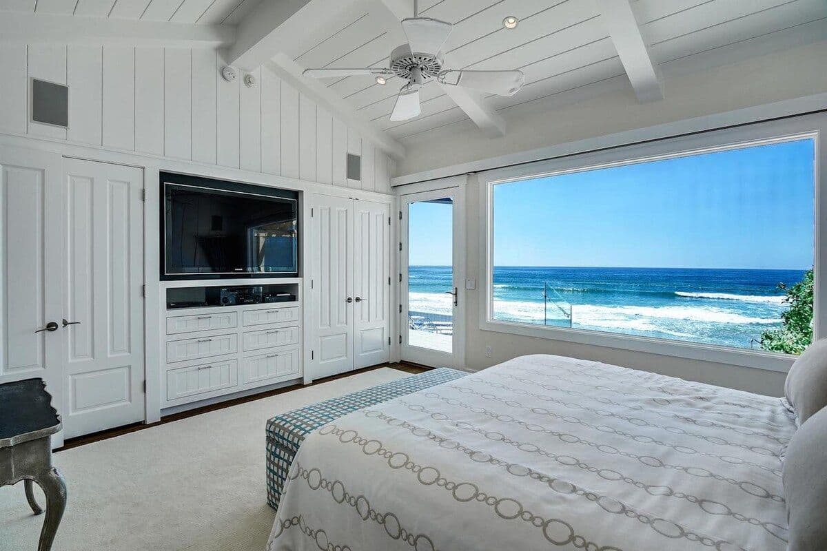 Bedroom with television and ocean-view window at Pearly Whites