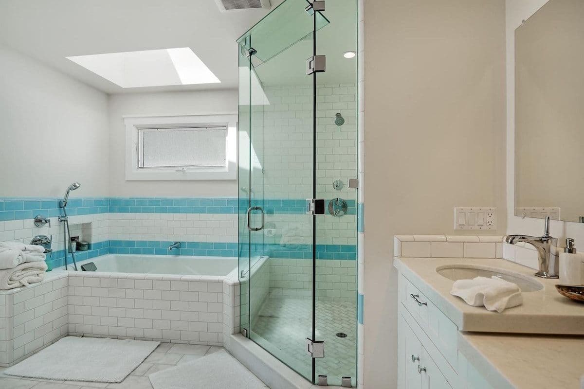 En-suite bathroom with soaking tub and skylight at Pearly Whites