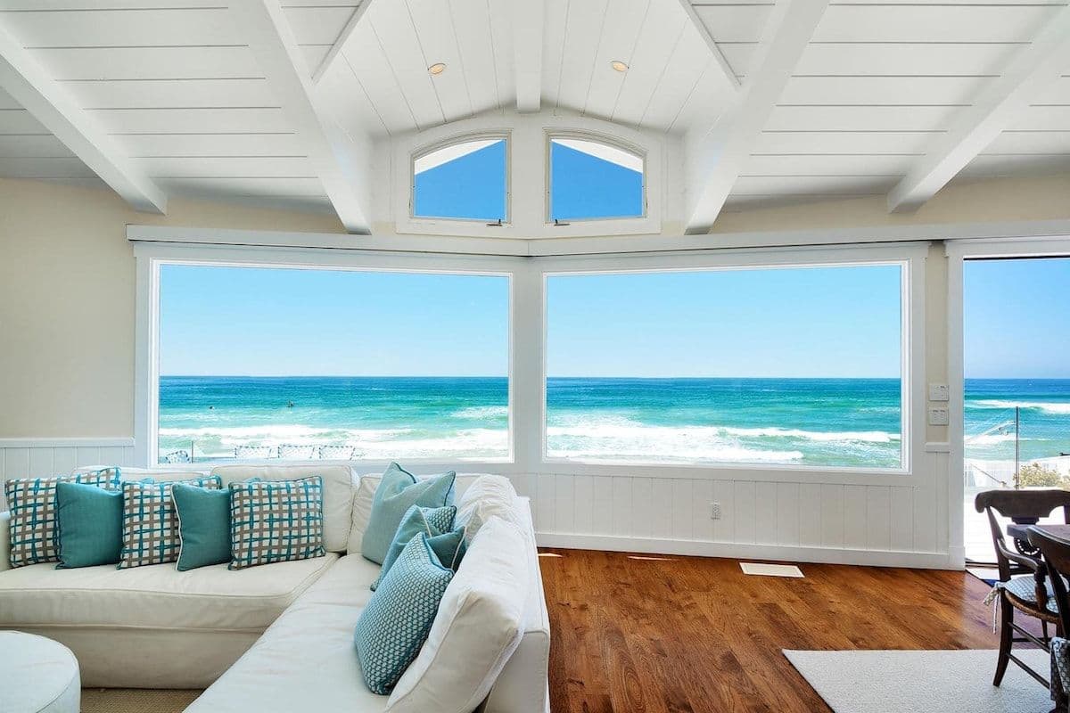 Living room with wraparound windows overlooking the ocean at Pearly Whites