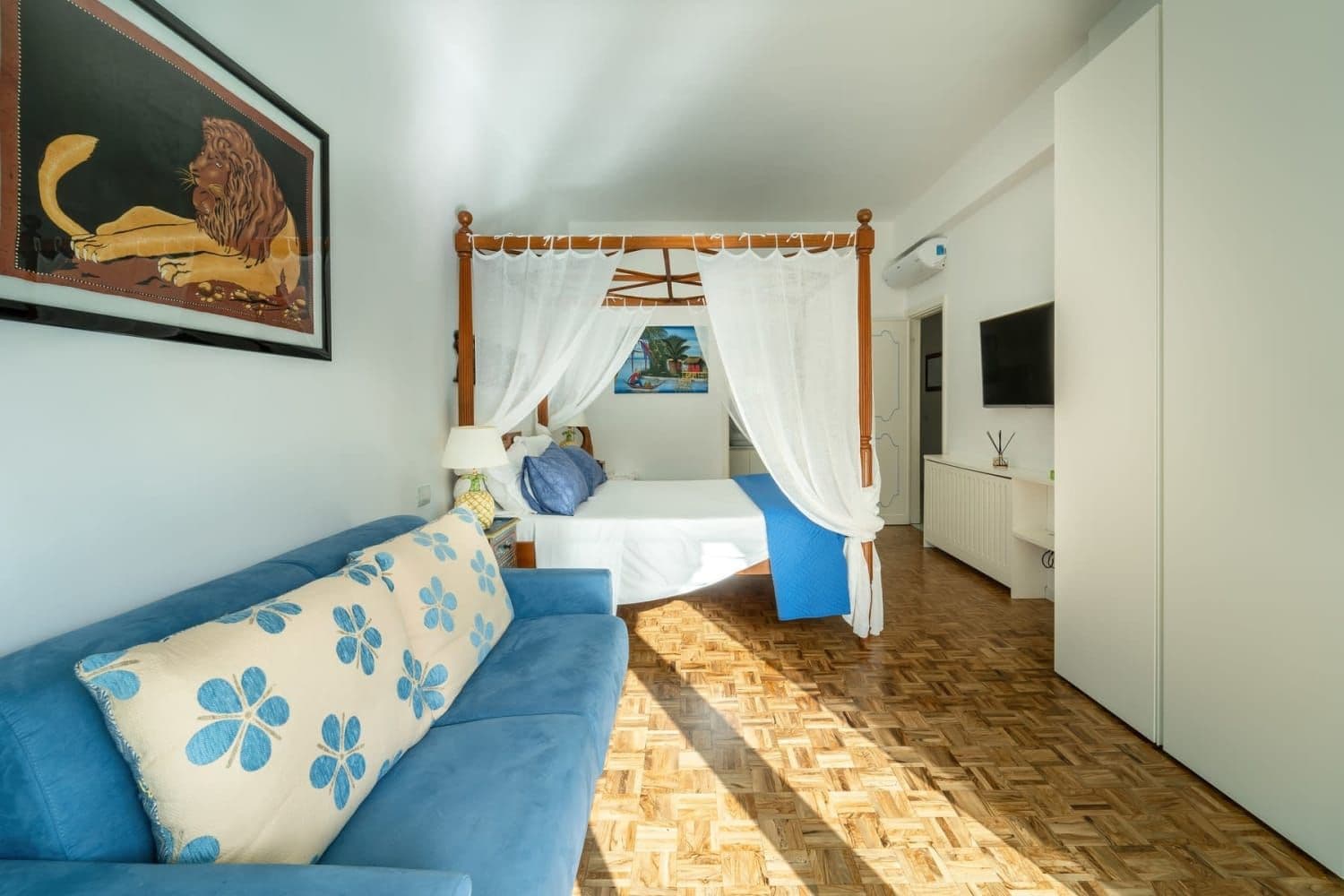 Canopy bedroom with additional seating area and floral cushions