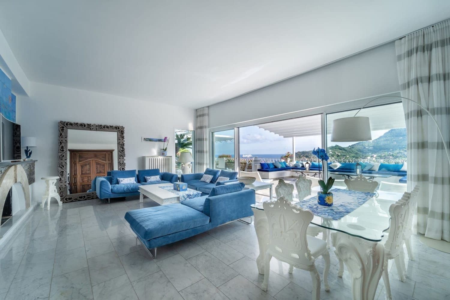 Open living and dining space with blue sofa and fireplace