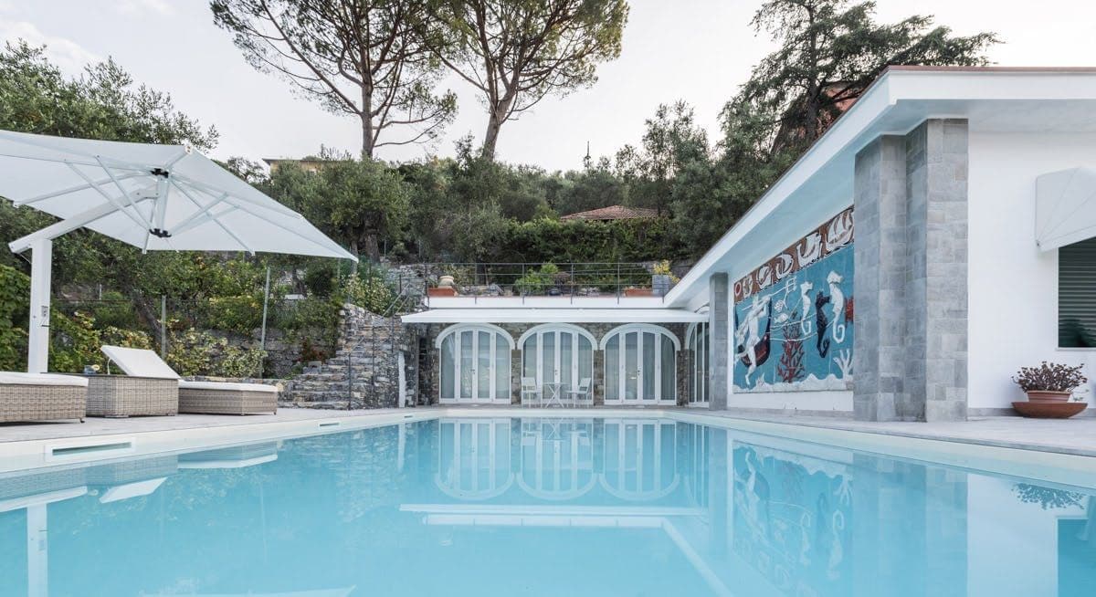 Pool terrace with sun loungers surrounded by pine trees