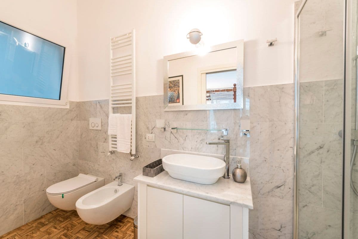 Marble bathroom with vessel sink and heated towel rail