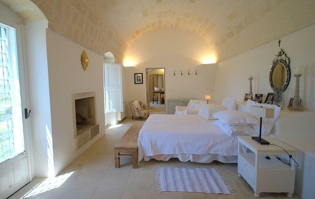 Bedroom with a vaulted ceiling, fireplace and crisp white linen