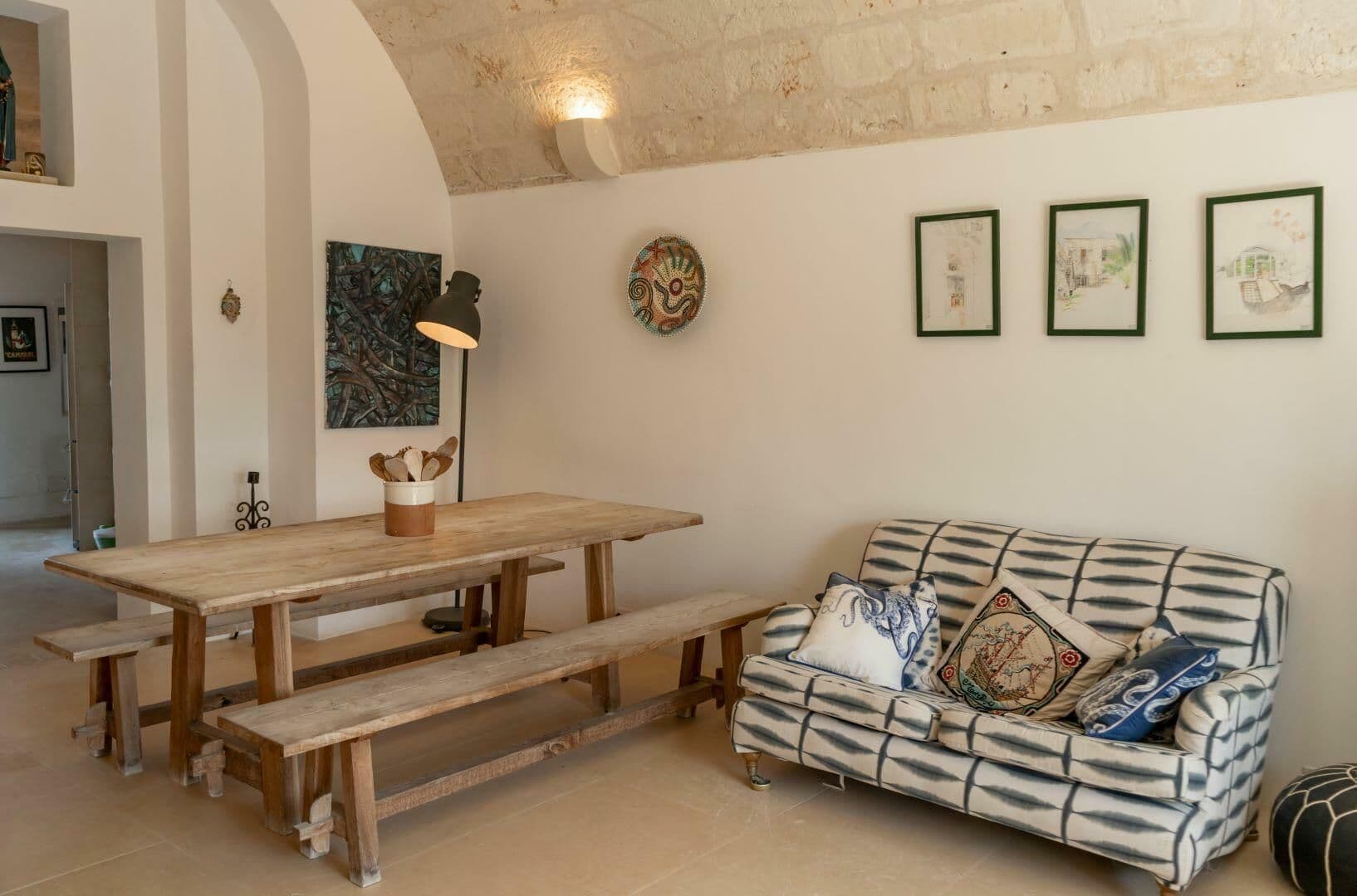 Wooden dining table and bench seating beneath a vaulted ceiling