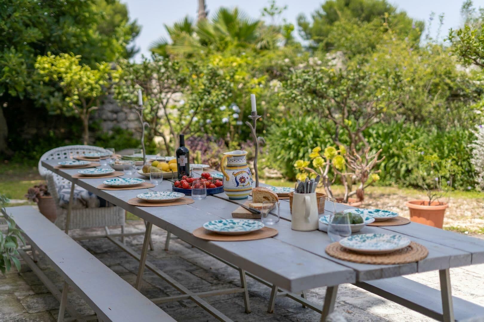 Outdoor dining table set for a group among mature garden planting