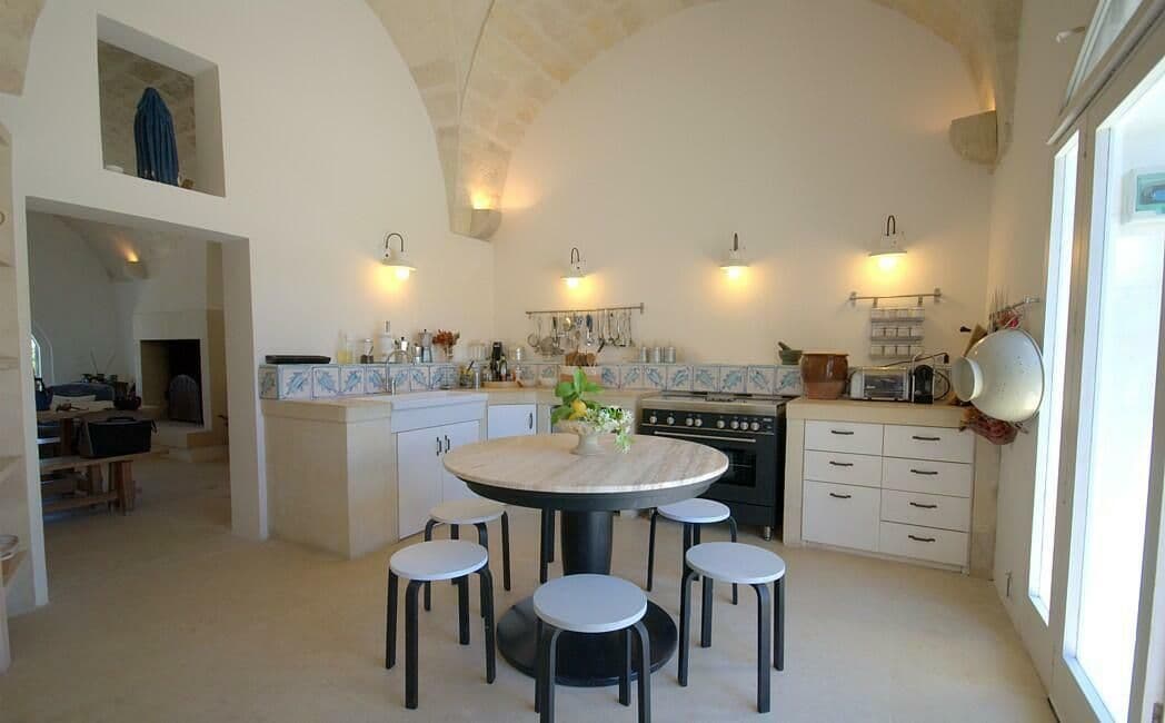 White farmhouse kitchen with a round table and stools