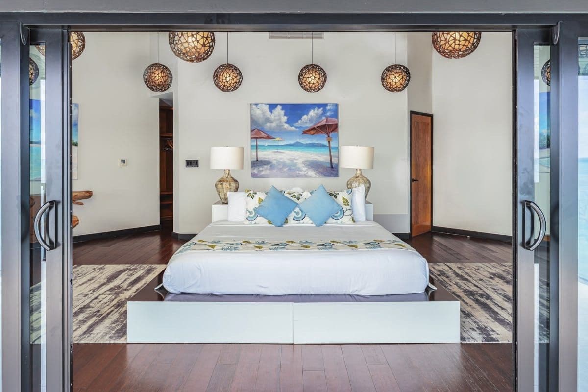 Master bedroom with woven pendants and dark timber floors at Sunlight Breeze, Antigua
