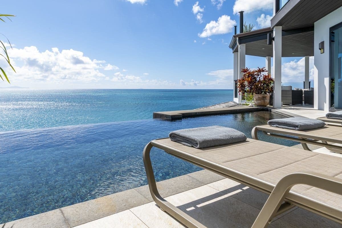 Lounger at the edge of the infinity pool over the sea at Sunlight Breeze, Antigua