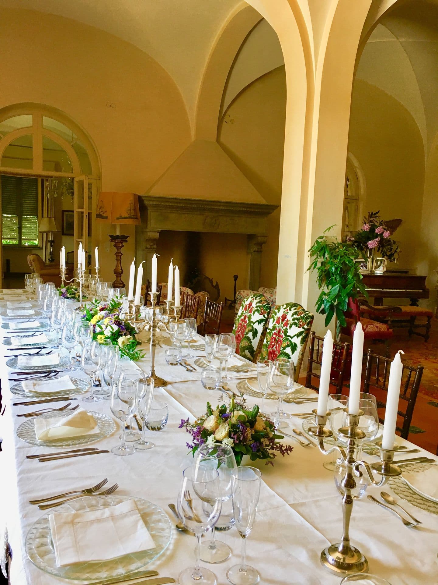 Long banquet table laid with white linen, candles and fresh flowers for a formal dinner at Midnight Ball