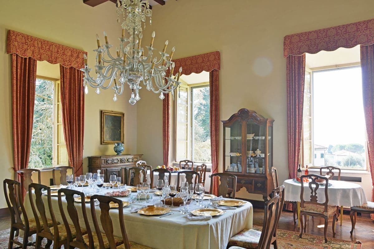 Formal dining room with a crystal chandelier and antique table set for a family meal at Midnight Ball