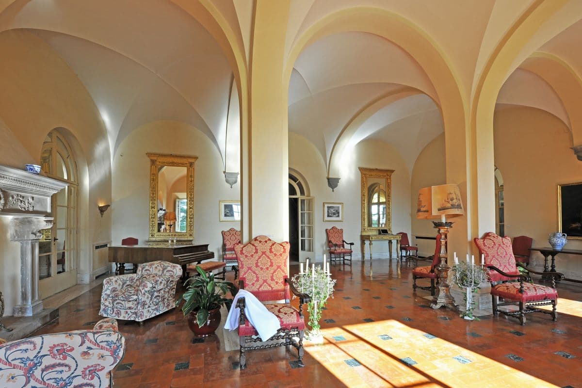 Vaulted stone hallway with arched doorways and antique furniture at Midnight Ball