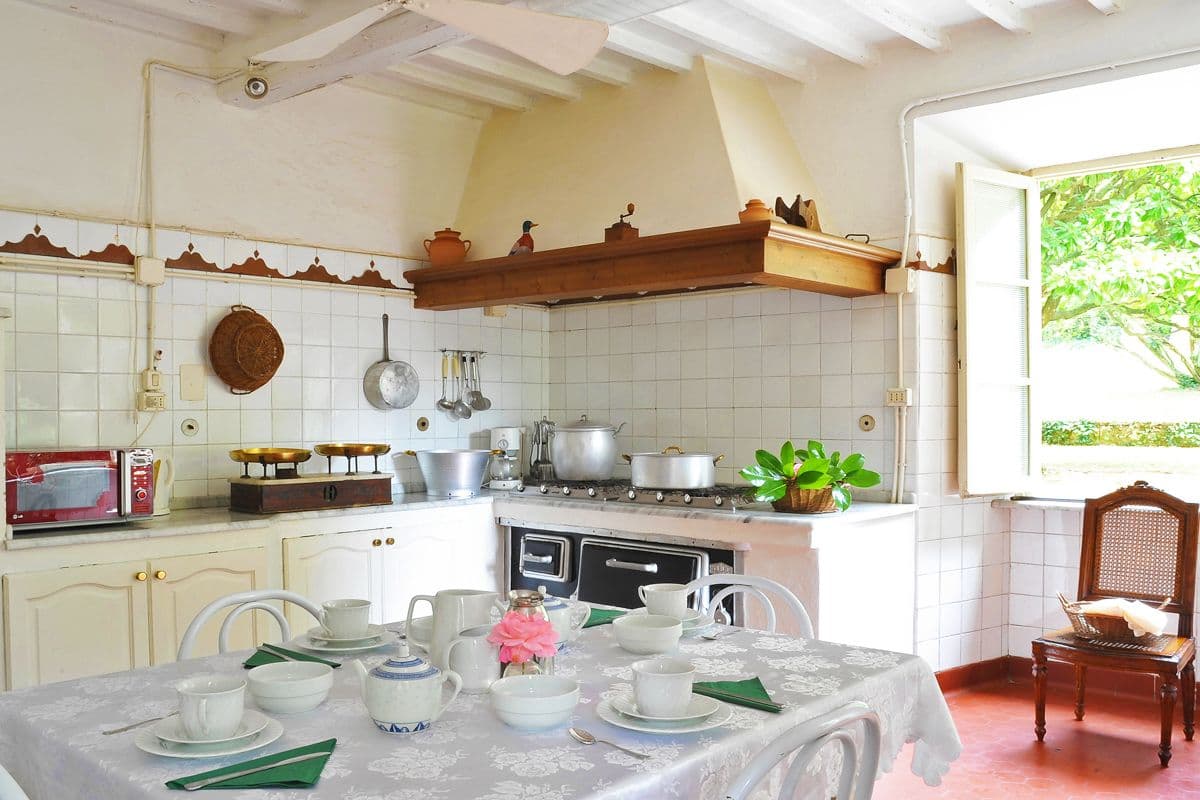 Traditional country kitchen with copper pans, a range cooker and a breakfast table at Midnight Ball