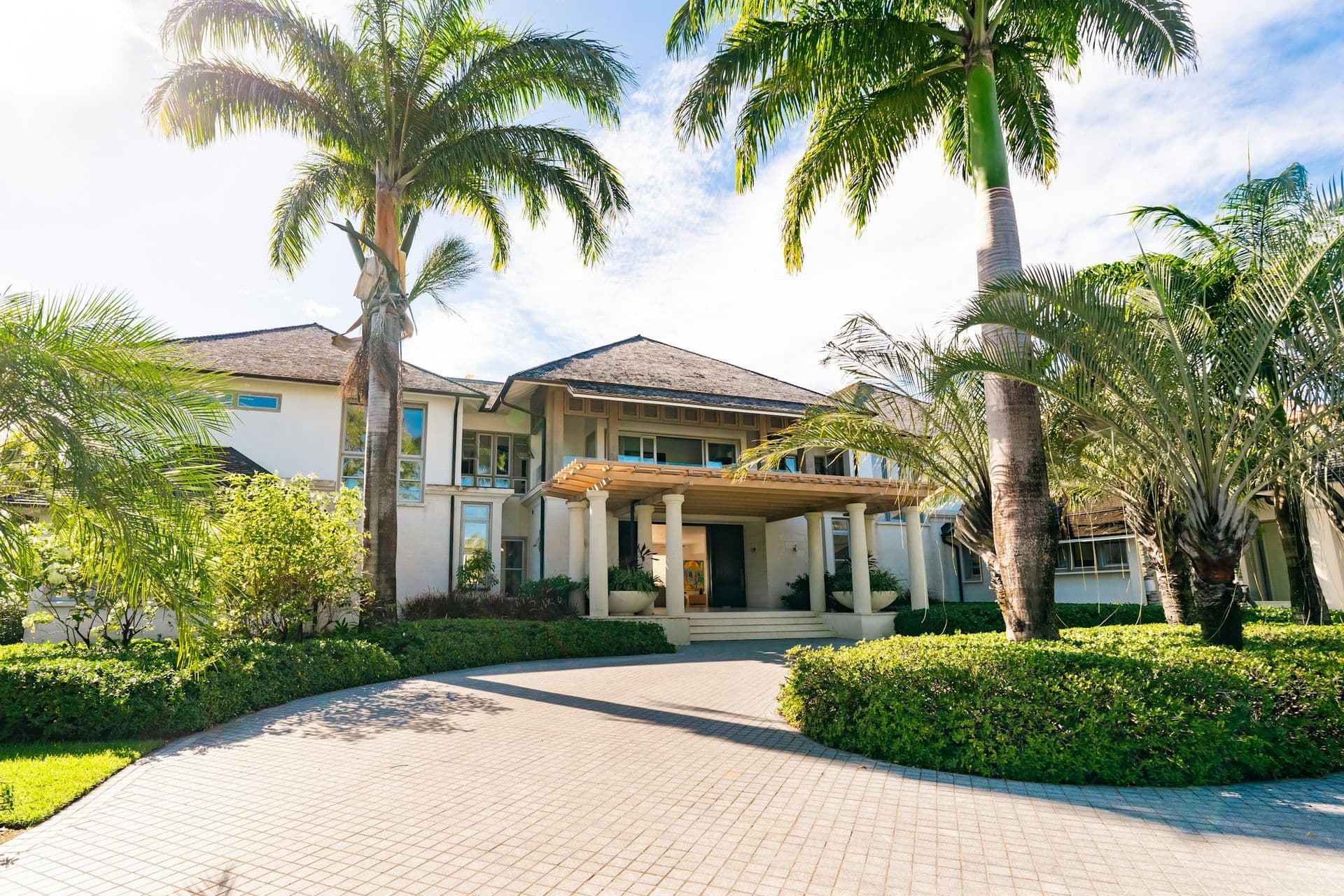 Entrance facade with a columned portico and palms at Moonlight Beauty, Barbados